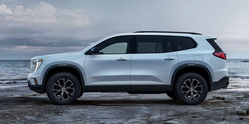 White 2026 GMC Acadia parked near the sea.