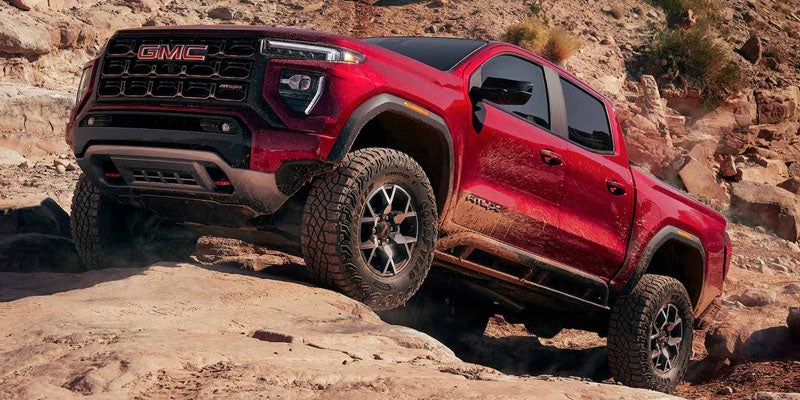 2026 GMC Canyon AT4X climbing rocky terrain showcasing off-road capability and rugged performance