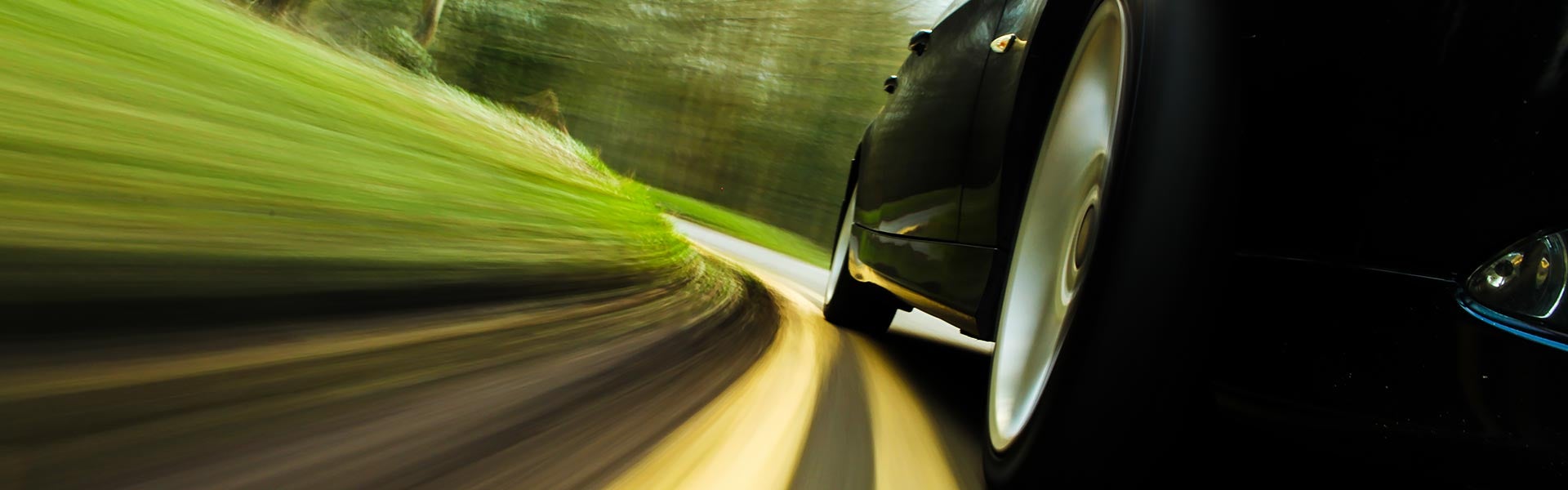 GMC vehicle driving on an open highway grassy curve during a road trip.